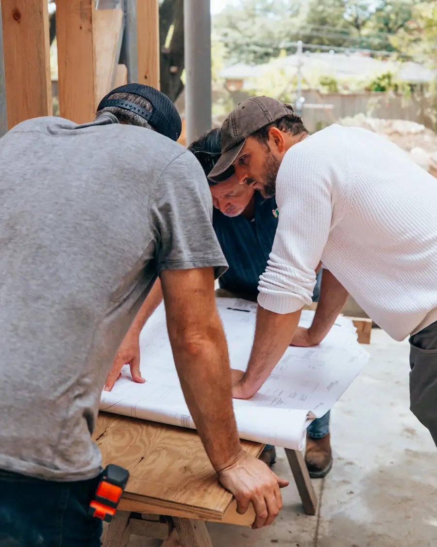 Project manager and builder reviewing plans on site